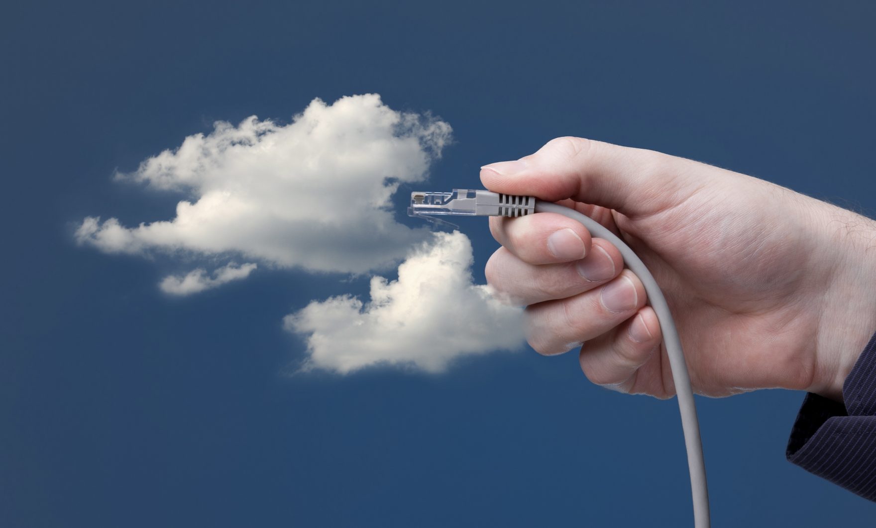Cloud computing concept. Hand with ethernet cable connecting into cloud.